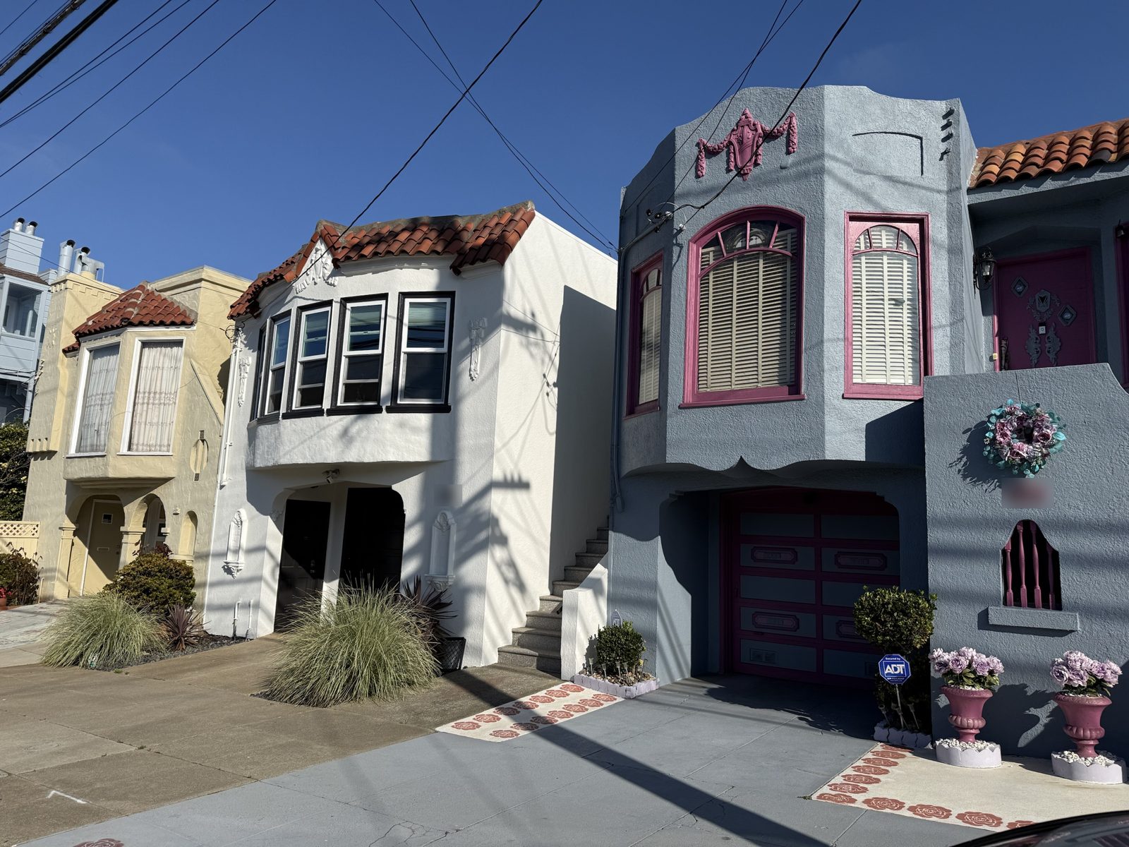 Classic Sunset District stucco homes with tile roofs, bay windows, and garages at street level